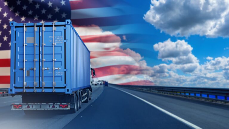 A truck driving down the road with an american flag painted on it.