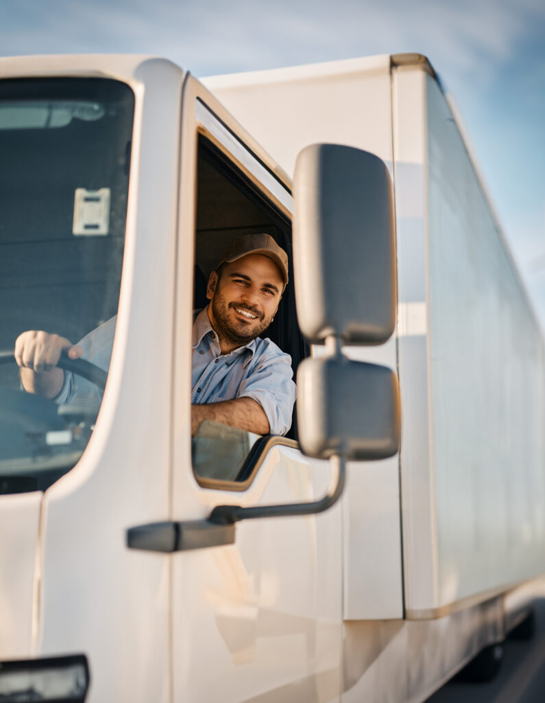 A man sitting in the drivers seat of a truck.